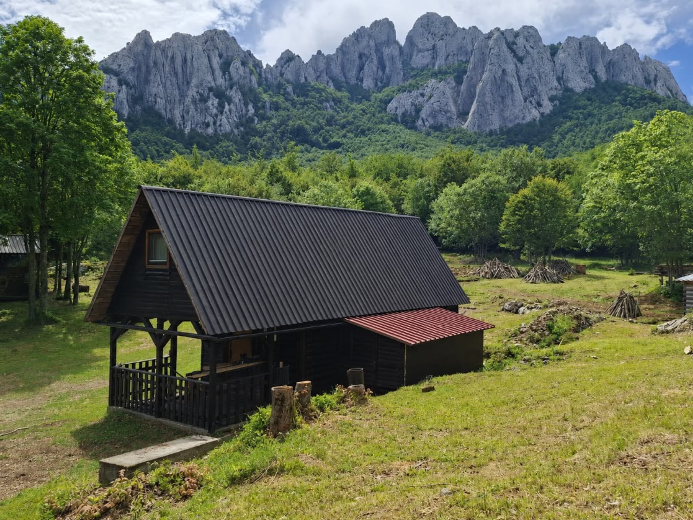 Stars Peak wooden cabin with Bačić Kuk rising above the forest